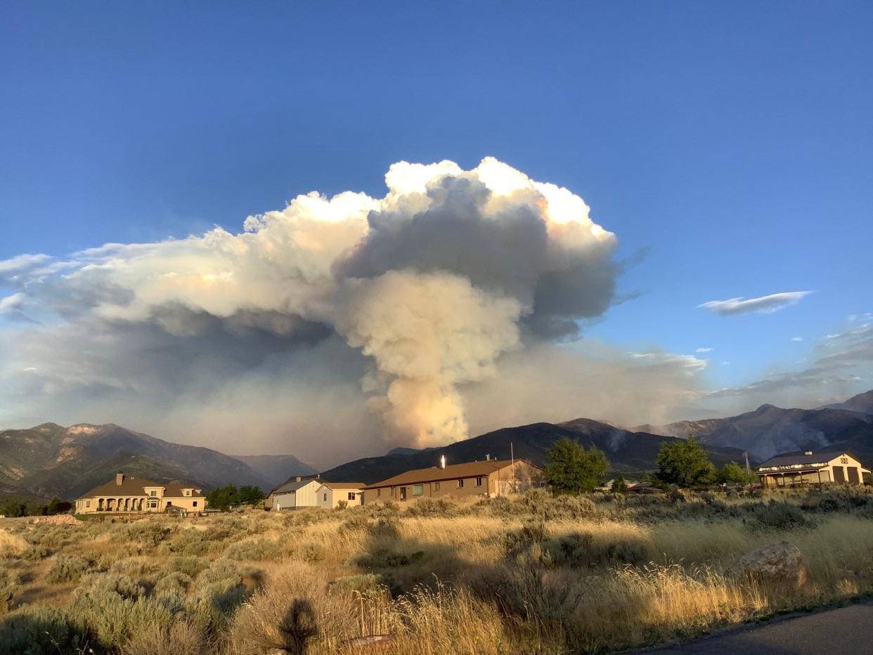 A large pillar of smoke rose up over the mountains in Millard County late Monday as the Halfway Hill Fire burned into areas of dead wood and other fuels near a campground.