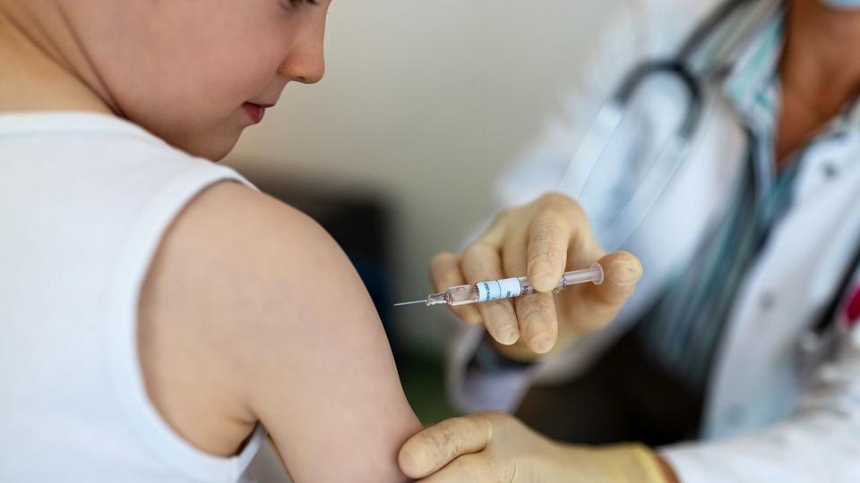 Boy getting a flu or coronavirus vaccine in the clinic