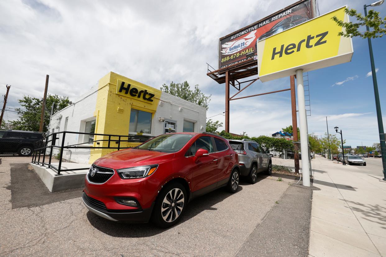 This May 23, 2020, photo shows rental vehicles parked outside a closed Hertz car rental office in south Denver. Hertz said Wednesday, June 17, it has put its plans to sell $500 million worth of stock on hold because the offering is being reviewed by the Securities and Exchange Commission. (AP Photo/David Zalubowski)