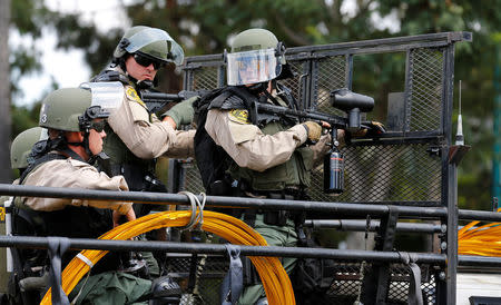 Los Angeles Sheriff Department deputies stand with non-lethal weapons behind a truck mounted barrier to disperse demonstrators after U.S. Republican presidential candidate Donald Trump spoke at a campaign event in Anaheim, California, U.S., May 25, 2016. REUTERS/Mike Blake