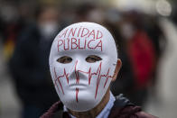 A demonstrator attends a protest to demand more resources for public health system in Madrid, Spain, Sunday, Nov. 29, 2020. The organizers delivered a manifesto to the Madrid regional authorities demanding the end privatization of the health system. The mask reads in Spanish "Public health system". (AP Photo/Bernat Armangue)