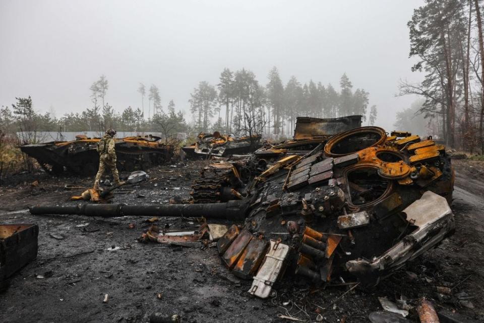 A Ukranian soldier walks near destroyed Russian tanks, in the outskirts of Kyiv, on April 1, 2022.