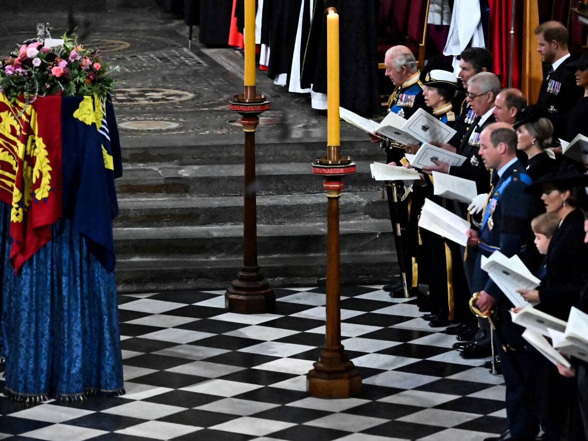 Members of the Royal Family sing as Queen Elizabeth's coffin lies by the altar during her state funeral at Westminster Abbey in London on Monday. Two choirs, organists, trumpeters and the Queen's Piper also performed during the service. (Ben Stansall/Reuters - image credit)