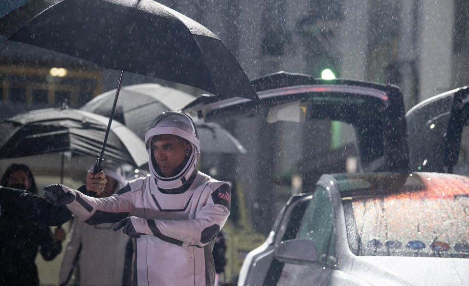 NASA astronaut Raja Chari, wearing a SpaceX spacesuit, points towards friends and family as he prepares to depart the Neil A. Armstrong Operations and Checkout Building for Launch Complex 39A to board the SpaceX Crew Dragon spacecraft for the Crew-3 mission launch, Wednesday, Nov. 10, 2021, at NASA’s Kennedy Space Center in Florida.