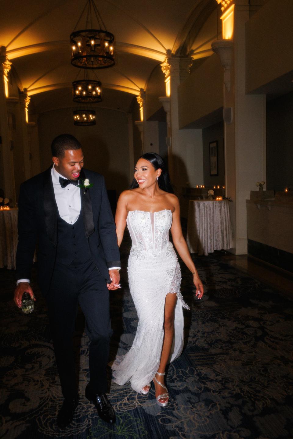 A bride and groom hold hands on their wedding day.