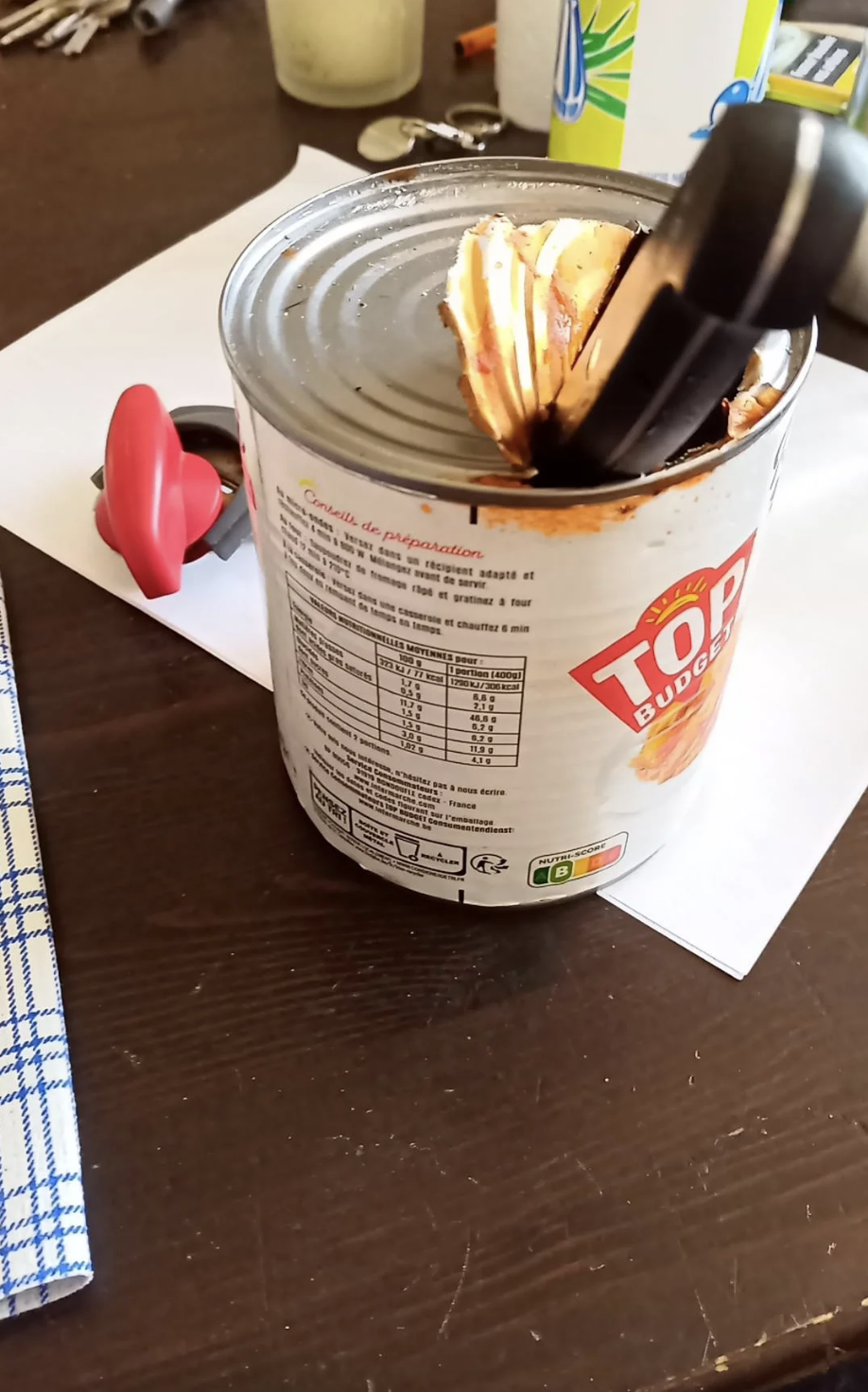 A can with the top hacked at, and a can opener right next to it, with the caption, "How my boyfriend opened a can of ravioli at midnight"