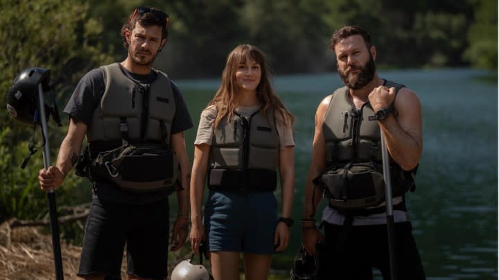 Three people stand in whitewater rafting gear in River Wild.