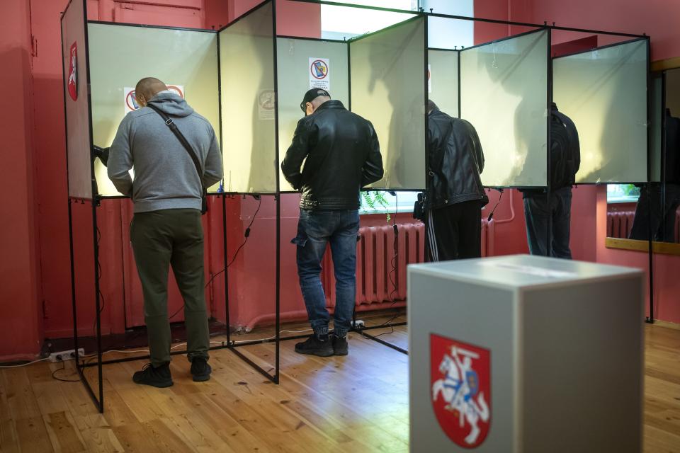 Local residents fills their ballots at a polling station during the first round of voting in presidential elections in Vilnius, Lithuania, Sunday, May 12, 2024. (AP Photo/Mindaugas Kulbis)