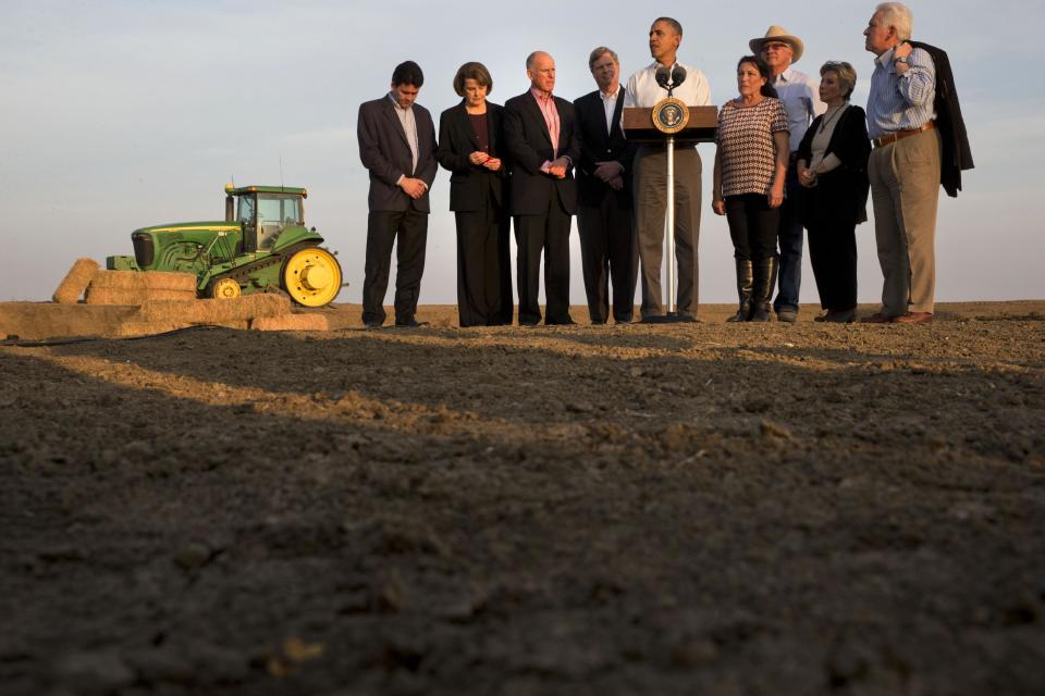 ** ADDS NAME OF PERSON AT FAR LEFT ** President Barack Obama, center, speaks about the drought after touring a local farm in Los Banos, Calif., Friday, Feb. 14, 2014, as from left, Michael Connor, commissioner of bureau of reclamation Sen. Dianne Feinstein, D-Calif., Calif. Gov. Jerry Brown, Agriculture Secretary Tom Vilsack, Obama, Maria Gloria Del Bosque of Empresas Del Bosque, Inc., Joe Del Bosque of Empresas Del Bosque, Inc., Sen. Barbara Boxer, D-Calif., and Rep. Jim Costa, D-Calif., listen. (AP Photo/Jacquelyn Martin)