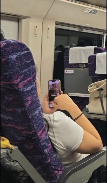 前方的女乘客正大剌剌地看謎片。（圖／翻攝自臉書社團「爆廢1公社」）