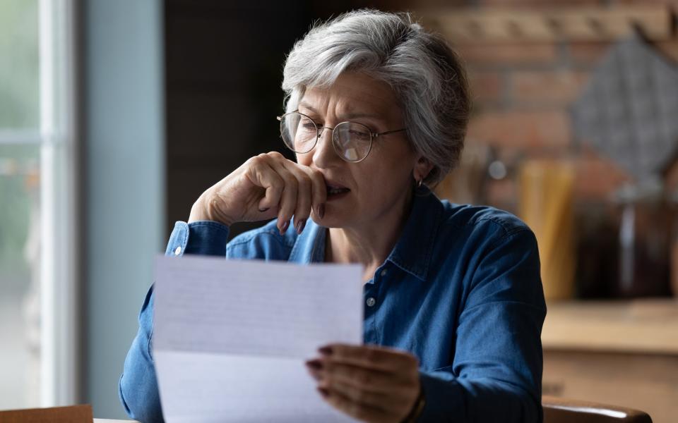 Distressed female pensioner checks documents at home