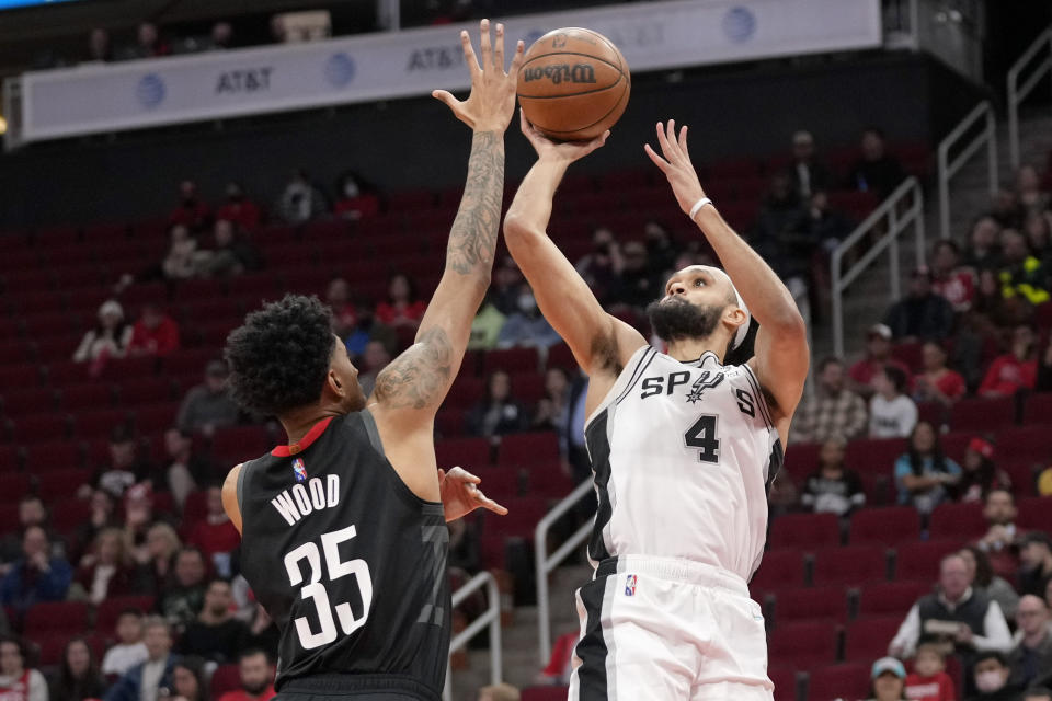 San Antonio Spurs guard Derrick White (4) shoots as Houston Rockets center Christian Wood defends during the first half of an NBA basketball game, Tuesday, Jan. 25, 2022, in Houston. (AP Photo/Eric Christian Smith)