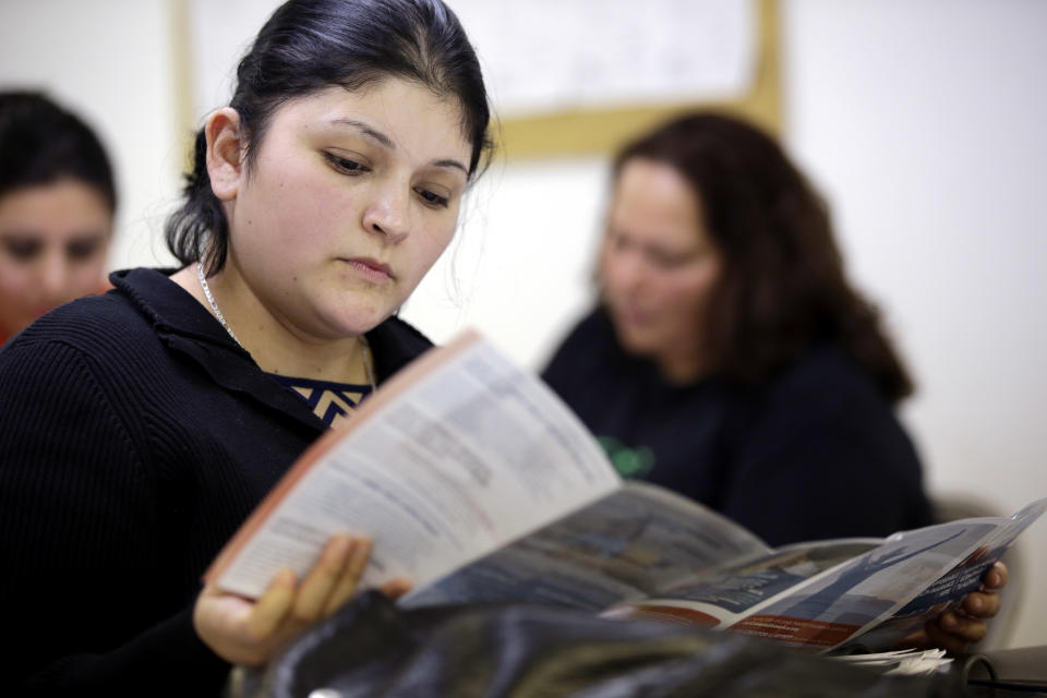 In this Tuesday, March 11, 2014 photo, Sara Rodriguez looks over an Affordable Care Act brochure, in Houston. Rodriguez, like others who gathered to listen to a presentation about President Barack Obama’s signature health care overhaul, says she can’t afford insurance, even for $50 a month. With two young children and barely $400 of disposable income a month, she struggles to feed her family. (AP Photo/David J. Phillip)