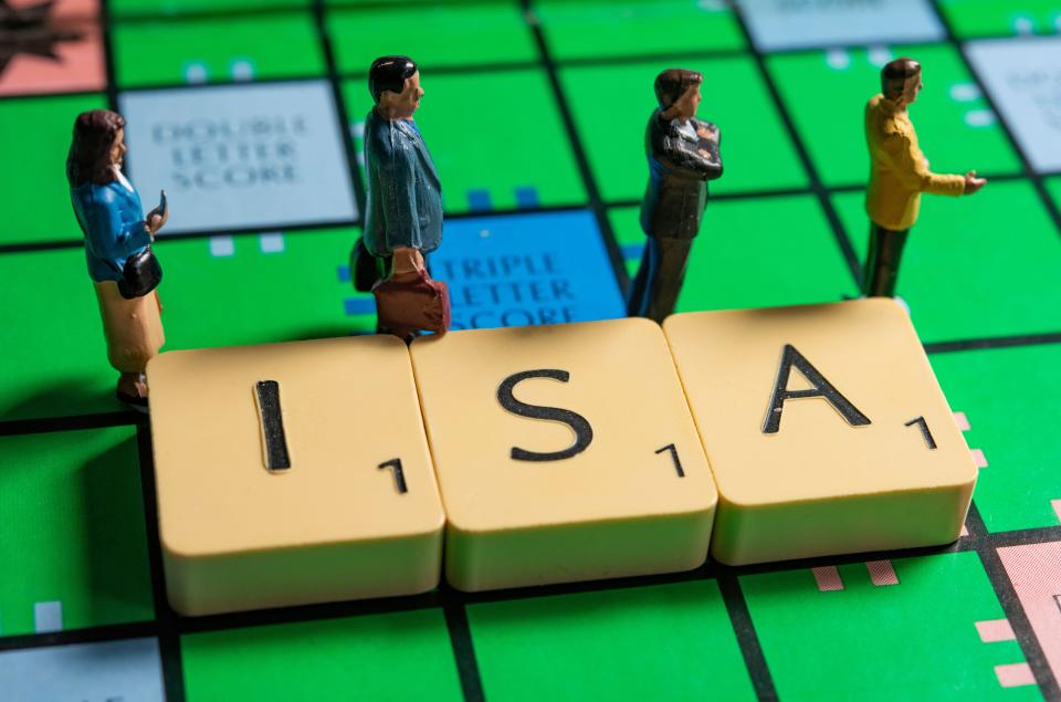 miniature figurines next to ISA letter on a scrabble board tax year
