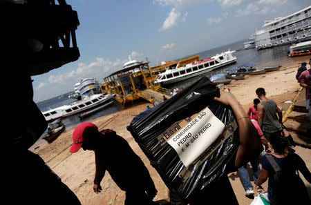 A Brazilian electoral worker carries a bag containing electronic ballot boxes to be transported to voting stations cross the Amazon River, at the Manaus Port, Brazil October 4, 2018. REUTERS/Bruno Kelly