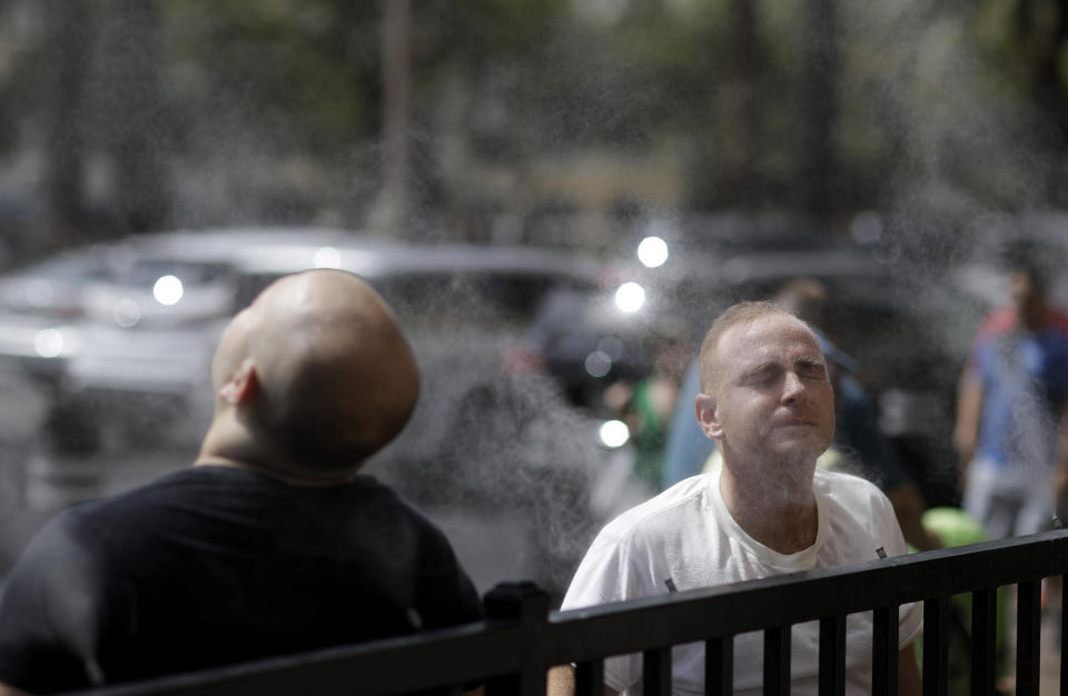 People cool off with a water mist along the Las Vegas Strip, Tuesday, July 24, 2018, in Las Vegas. The National Weather Service has issued an excessive heat warning for the Las Vegas valley. (AP Photo/John Locher)