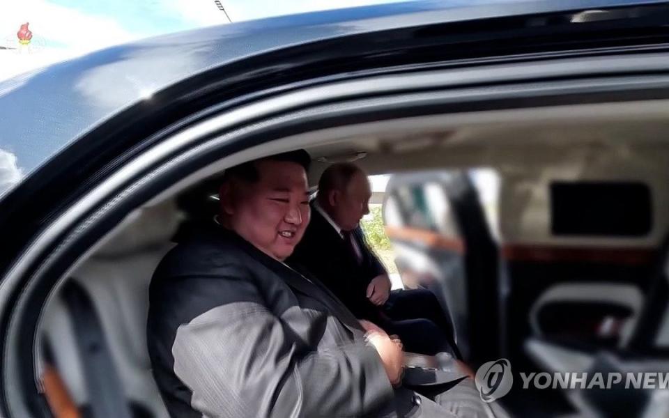 Kim Jong-un (L) and Vladimir Putin taking a ride in Putin's presidential Aurus Senat limousine
