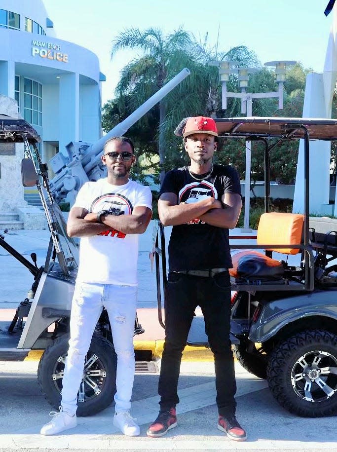 In this May 1, 2023, photo provided by Carven Exantus, 34, of Miami, left, Exantus and his business partner, Fred Laurice Johnson, 33, are seen standing in front of golf carts used by their business, Crew Cart Services LLC, near the Miami Beach Police Department headquarters.  Exantus has been ticketed five times under a new law that allows police and sheriff's deputies to ticket drivers for music that can be heard more than 25 feet away. Johnson has been ticketed four times. A new analysis of traffic data and court records shows Black drivers in Florida are nearly three times more likely to be ticketed under the law, which took effect last year.