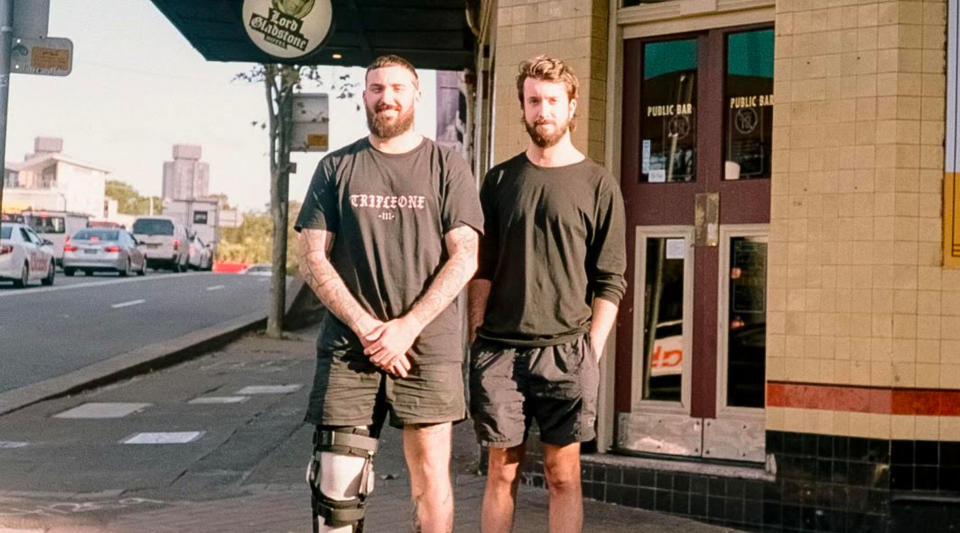 Two pub owners standing outside the pub. 