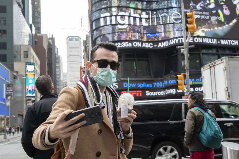 美國新冠肺炎（武漢肺炎）疫情持續升溫，紐約時報廣場上的遊客也戴起口罩（AP）