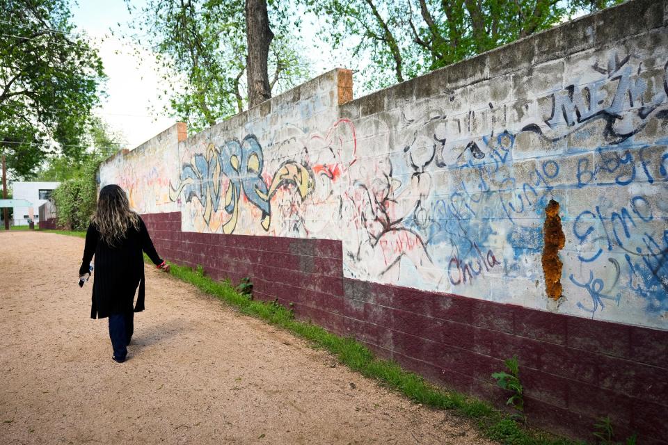 Arte Texas Executive Director Bertha Rendon-Delgado looks at faded murals at the decommissioned Holly Power Plant. She wants the city to commit to restoring the works.