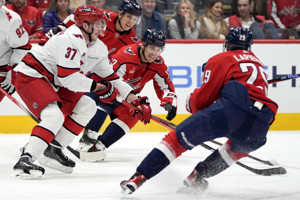 Carolina Hurricanes right wing Andrei Svechnikov (37), left, and Washington Capitals center Dylan Strome (17) battle for control of the puck in the first period of an NHL hockey game, Friday, Jan. 5, 2024, in Washington. (AP Photo/Mark Schiefelbein)