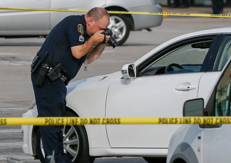 <p>Houston Police investigators photograph a vehicle that received gunshot damage during a scene where nine were wounded in a strip mall shooting on September 26, 2016 in Houston, Texas. (Bob Levey/Getty Images) </p>