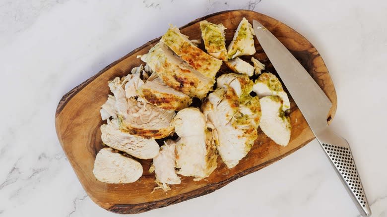 Diced pesto chicken breasts on a cutting board