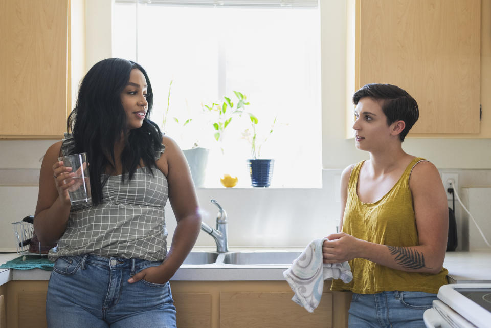 two friends looking at each other in kitchen