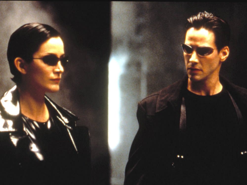 Schwarze Leder-Outfits und Sonnenbrillen: Carrie-Anne Moss und Keanu Reeves in "Matrix". (Bild: imago images/Everett Collection/Warner Bros.)