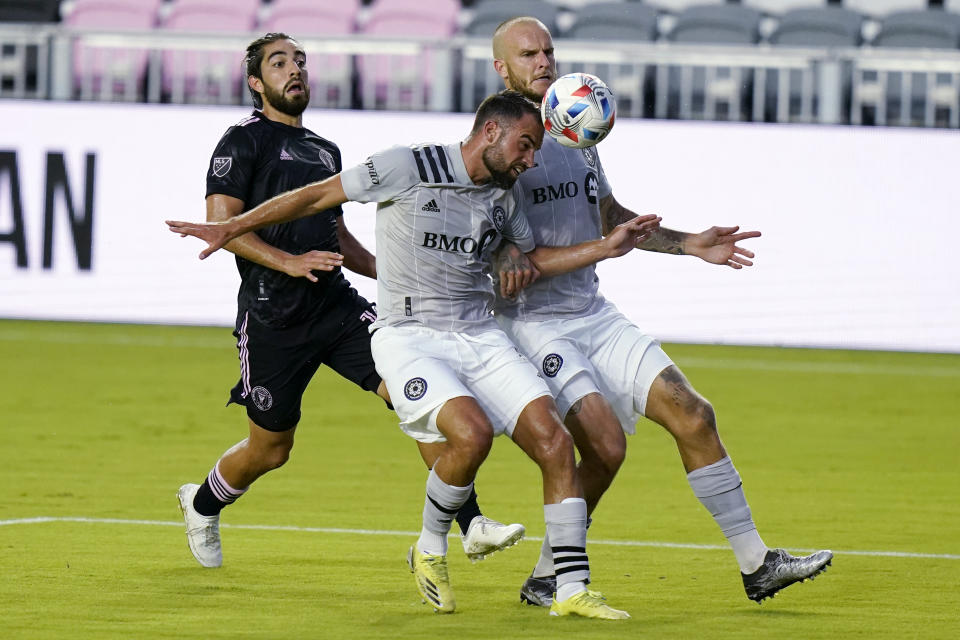 Inter Miami midfielder Rodolfo Pizarro, left, watches as Montreal defender Rudy Camacho, center, heads the ball during the first half of an MLS soccer match, Wednesday, May 12, 2021, in Fort Lauderdale, Fla. At right is Montreal defender Aljaz Struna. (AP Photo/Lynne Sladky)