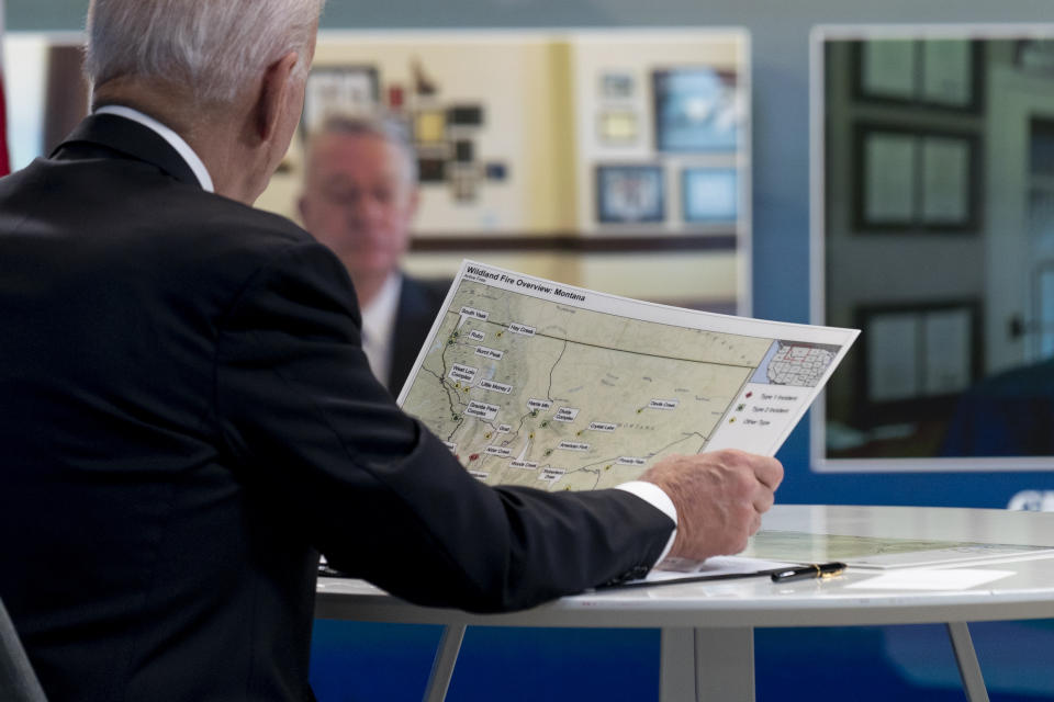 President Joe Biden looks at a map of wildfires in Montana as he speaks with governors about ongoing efforts to strengthen wildfire prevention, preparedness and response efforts, and hear firsthand about the ongoing impacts of the 2021 wildfire season in the South Court Auditorium in the Eisenhower Executive Office Building on the White House Campus in Washington, Friday, July 30, 2021. (AP Photo/Andrew Harnik)