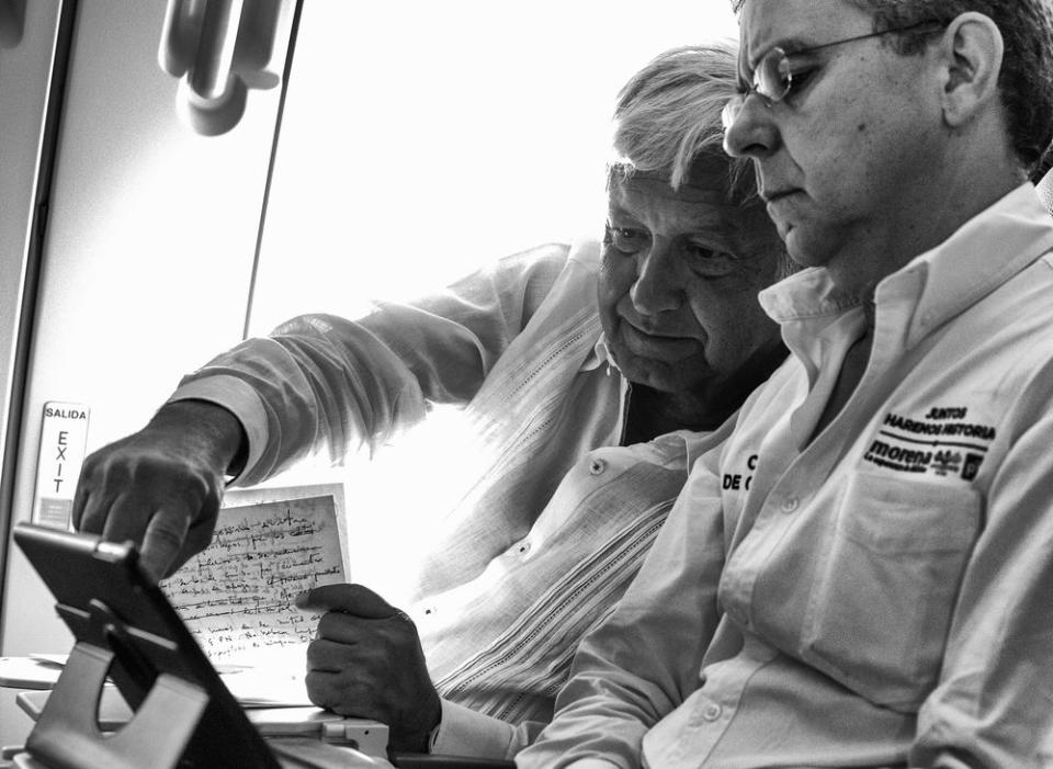 López Obrador works on a final campaign speech, alongside his Press Secretary César Yáñez, on a commercial flight to Cancún ahead of the July 1 elections.