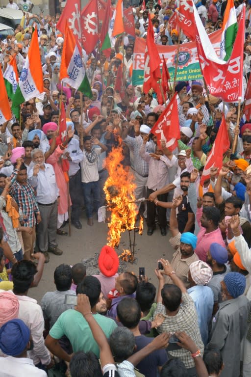 Leftist activists shout slogans as they burn an effigy of Indian Prime Minister Narendra Modi during a nationwide strike against the central government in Amritsar, northwest India on September 2, 2015