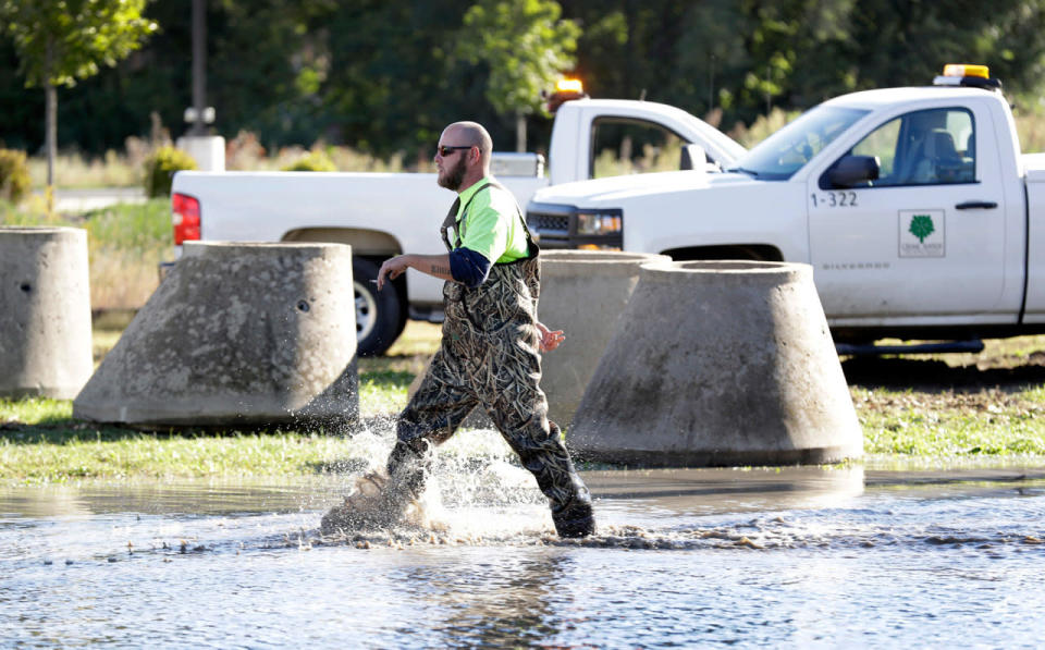 <p>A worker walks through water after repairing a pump near a levee next to the flood swollen Cedar River, Tuesday, Sept. 27, 2016, in Cedar Rapids, Iowa. (AP Photo/Charlie Neibergall)</p>