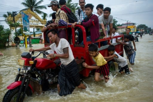 Some stranded people were plucked from the churning inundations by rescuers in boats, while others waded through waist-deep water to escape, carrying children on their shoulders while trying to keep precious belongings out of the water