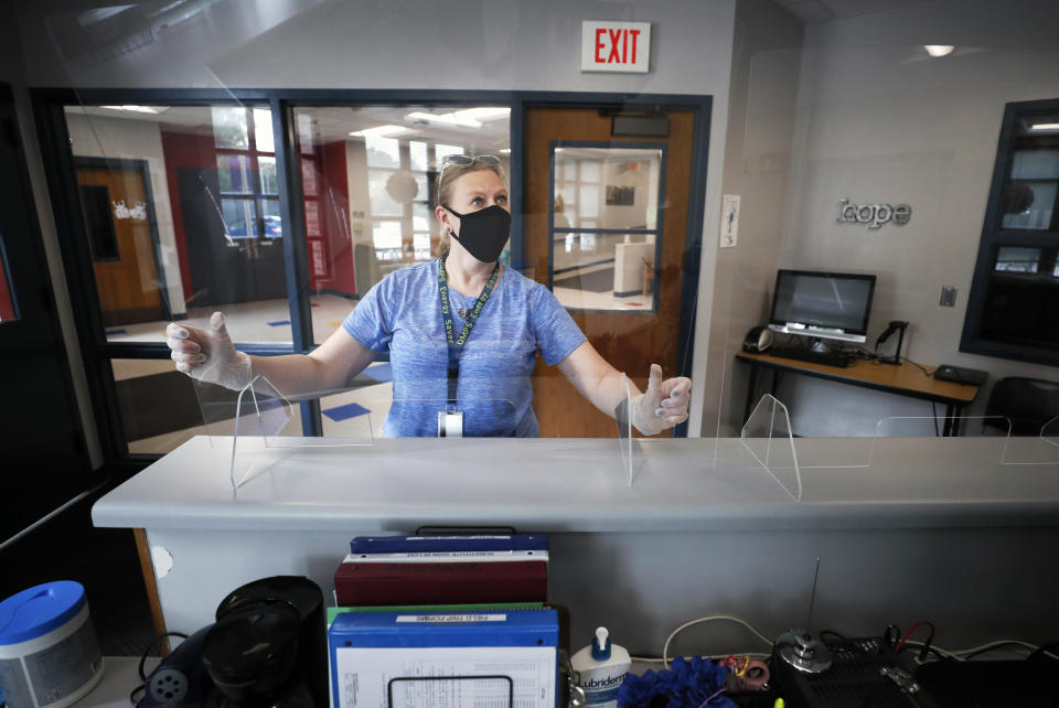 Des Moines Public Schools employee Sarah Holland installs a plexiglass shield in the office at Oak Park Elementary School on July 30, 2020, in Des Moines, Iowa. (Photo: ASSOCIATED PRESS)