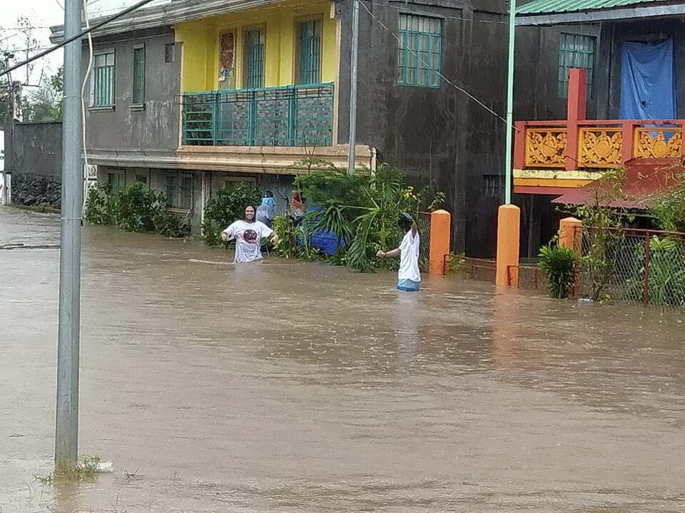 Residents walk along floodwaters in Daraga, Albay province, central Philippines as Typhoon Goni hit the area Sunday, Nov. 1, 2020. The super typhoon slammed into the eastern Philippines with ferocious winds early Sunday and about a million people have been evacuated in its projected path, including in the capital where the main international airport was ordered closed. (AP Photo/Alejandro Miraflor)