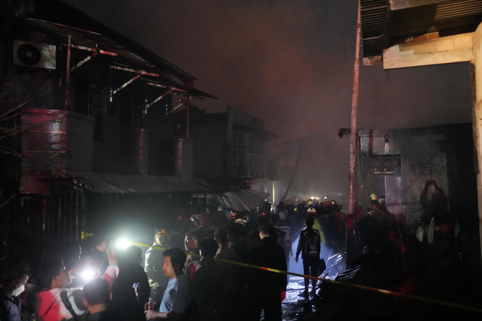 Rescuers inspect a neighborhood affected by a large fire in Jakarta, Indonesia, Friday March 3, 2023. The fire broke out at a fuel storage depot in Indonesia's capital on Friday, killing a number of people, injuring dozens of others and forcing the evacuation of thousands of nearby residents after spreading to their neighborhood, officials said. (AP Photo/Dita Alangkara)