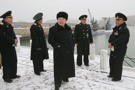 North Korean leader Kim Jong Un (C) smiles as he inspects the Korean People's Army (KPA) navy Unit 189 honoured with the title of "O Jung Hup-led 7th Regiment", in this undated photo released by North Korea's Korean Central News Agency (KCNA) in Pyongyang December 13, 2014. REUTERS/KCNA