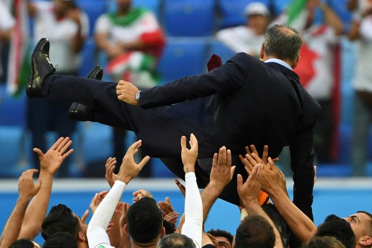 Iran's players threw coach Carlos Queiroz into the air after their late win against Morocco