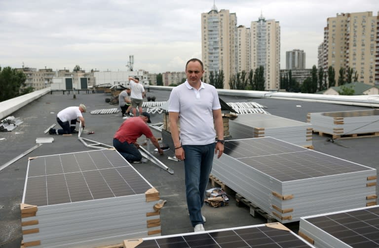 Nazariï Guitchka, directeur de la maternité de Kiev, sur le toit de l'établissement où des ouvriers installent des panneaux solaires, le 14 juin 2024 en Ukraine (Anatolii STEPANOV)