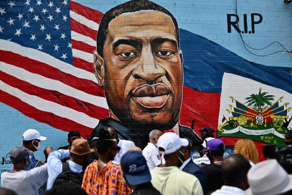People gather at the unveiling in Brooklyn, N.Y., of artist Kenny Altidor's memorial portrait of George Floyd, who died on Memorial Day 2020 in Minneapolis after police officer Derek Chauvin kneeled on his neck for more than nine minutes.