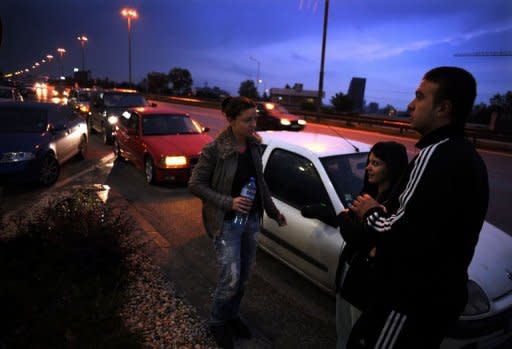 People stand next to their cars, parked on the Sofia ring road after a strong quake, in the Bulgarian capital early on May 22, 2012. The 5.8-magnitude quake rocked Bulgaria shortly after 3:00 am (0000 GMT)