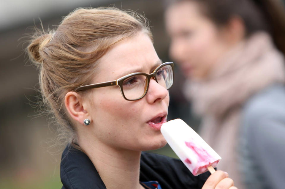 BERLIN, GERMANY - JULY 21: An attendee with horn-rimmed glasses eats ice cream at the second annual Hipster Olympics on July 21, 2012 in Berlin, Germany. With events such as the "Horn-Rimmed Glasses Throw," "Skinny Jeans Tug-O-War," "Vinyl Record Spinning Contest" and "Cloth Tote Sack Race," the Hipster Olympics both mocks and celebrates the Hipster subculture, which some critics claim could never be accurately defined and others that it never existed in the first place. The imprecise nature of determining what makes one a member means that the symptomatic elements of adherants to the group vary in each country, but the archetype of the version in Berlin, one of the more popular locations for those following its lifestyle, along with London and Brooklyn, includes a penchant for canvas tote bags, the carbonated yerba mate drink Club Mate, analogue film cameras, an asymetrical haircut, 80s neon fashion, and, allegedly, a heavy dose of irony. To some in Berlin, members of the hipster "movement" have replaced a former unwanted identity in gentrifying neighborhoods, the Yuppie, for targets of criticism, as landlords raise rents in the areas to which they relocate, particularly the up-and-coming neighborhood of Neukoelln. (Photo by Adam Berry/Getty Images)