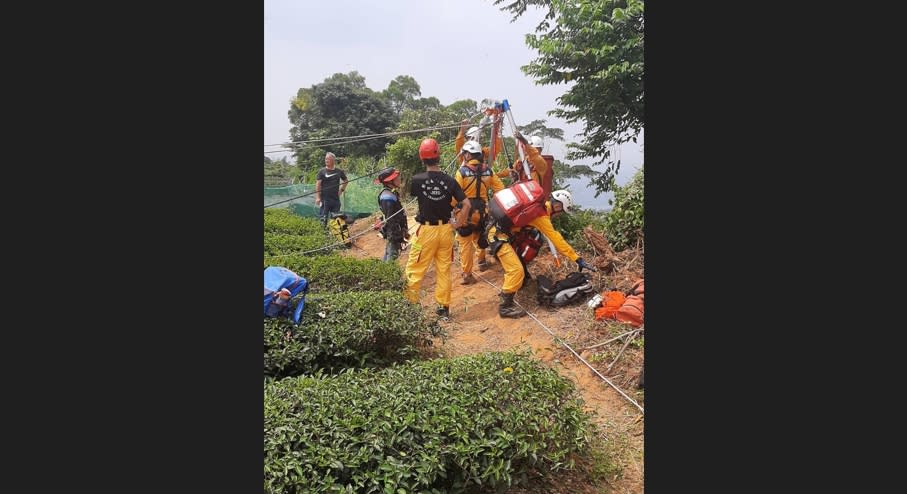 南投縣名間鄉弓鞋巷疑有茶園外籍移工偷吃果園波羅蜜，員警獲報17日前往了解，不料移工們見到警察四處逃竄，其中2人還跳下山谷邊坡，另有1人逃逸，消防局獲報到場架設繩索，救出跳下山谷的2名男移工。（中央社／民眾提供）
