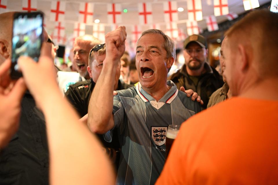 Leader of Reform UK Nigel Farage wearing a 1996 England football shirt joins England football fans watching a live broadcast of the UEFA Euro 2024 Group C football match between Denmark and England at The Armfield Club in Blackpool, northwestern England, on June 20, 2024, in the build-up to the UK general election on July 4.