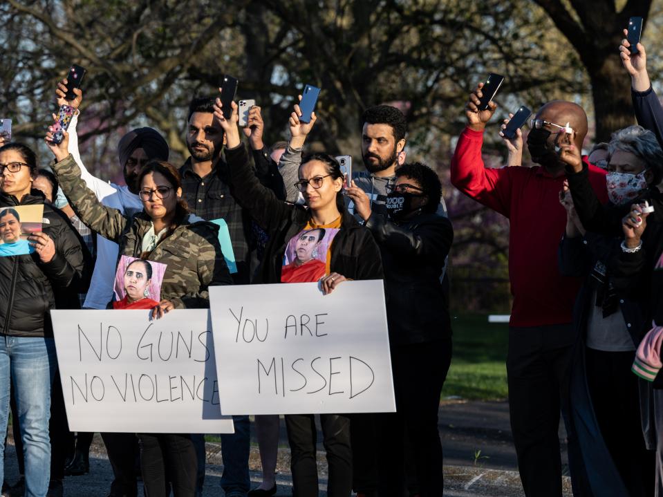 Families, coworkers, and government officials raise their cell phone flashlights during a vigil on April 17, 2021 in Indianapolis, Indiana. (Getty Images)