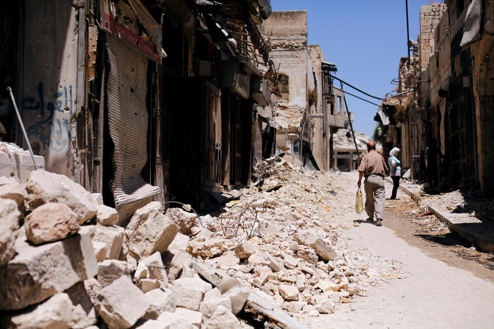 <p>A man walks past damaged houses in the Old City of Aleppo, Syria, July 13, 2017. (Photo: Omar Sanadiki/Reuters) </p>