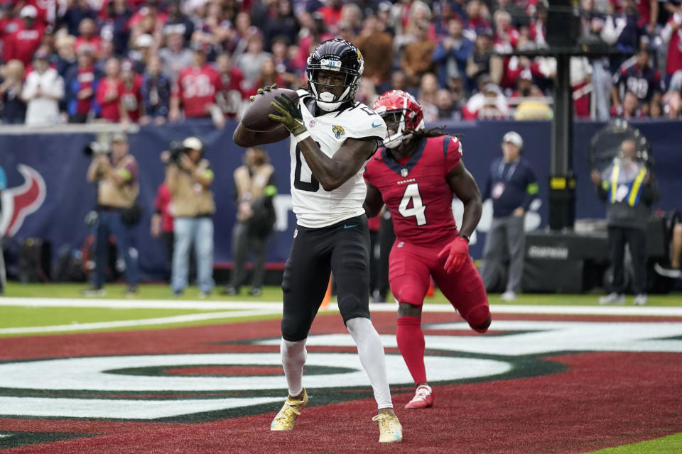 Jacksonville Jaguars wide receiver Calvin Ridley (0) catches a touchdown pass in front of Houston Texans cornerback Tavierre Thomas (4) in the second half of an NFL football game in Houston, Sunday, Nov. 26, 2023. (AP Photo/Eric Gay)